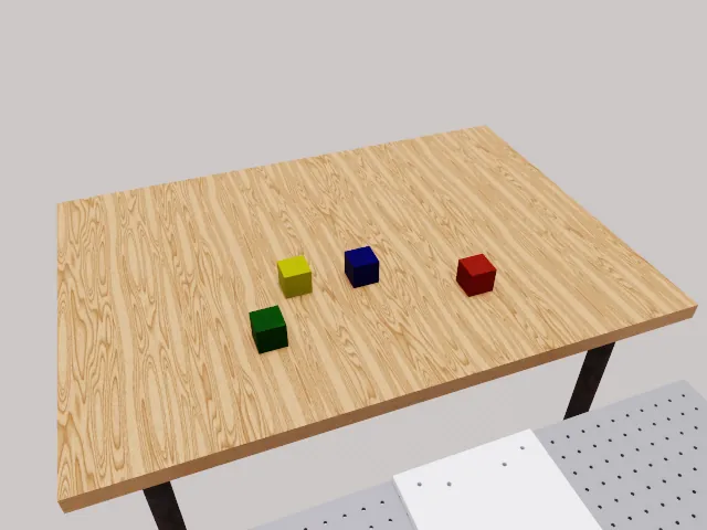 RoboLab scene: four colored blocks on a tabletop for stacking tasks.